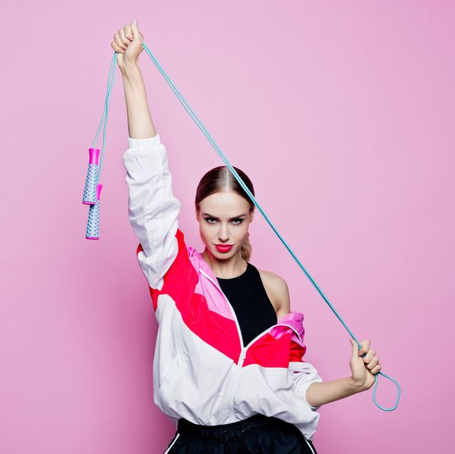 80's style portrait of confident woman in sports clothing against pink background