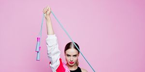 80's style portrait of confident woman in sports clothing against pink background