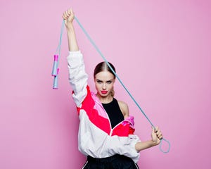 80's style portrait of confident woman in sports clothing against pink background