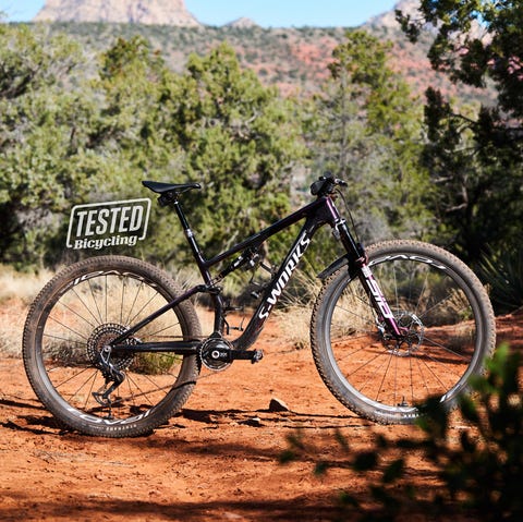 a bicycle parked on a dirt path