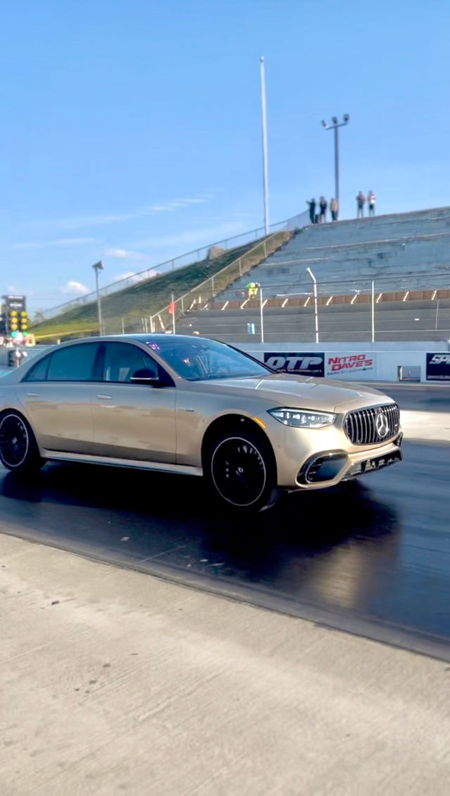 luxury sedan accelerating on a drag strip