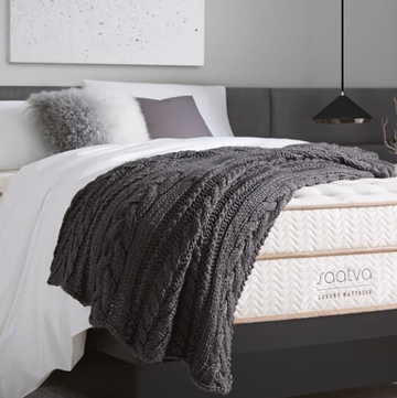 a white and gold mattress on a charcoal gray bed frame from saatva