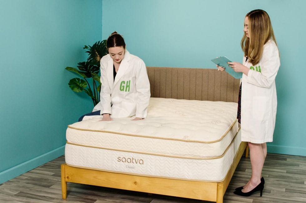 a lab expert sitting on the saatva classic mattress