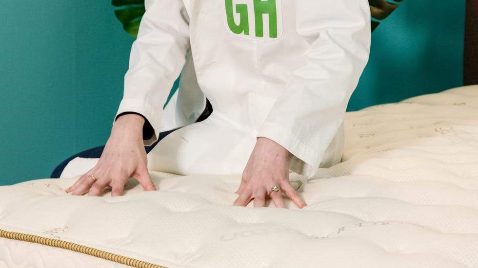 hands pressing on a saatva mattress to assess perceived bounce and pressure relief