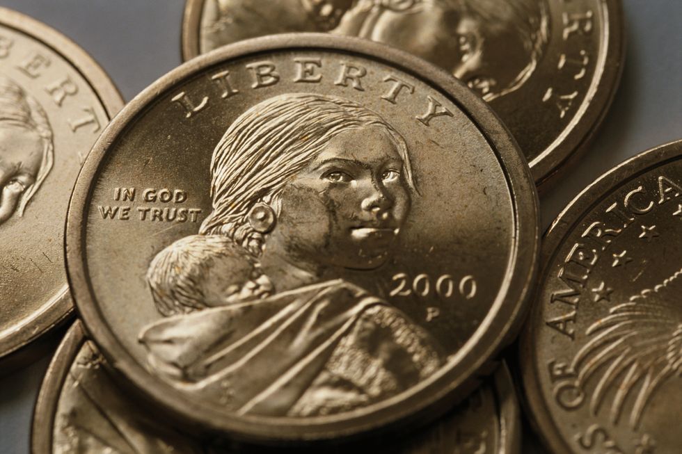 a pile of golden coins each with a portrait of sacagawea looking over her shoulder at the front