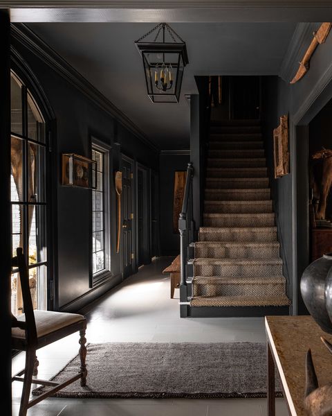 entryway, stairs, carpeted stairs, white tiles, black painted walls, black crown moulding