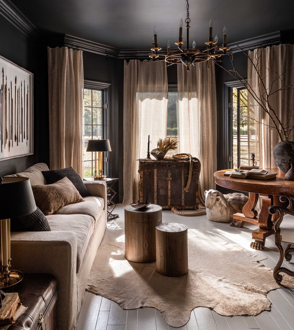 living room, animal skin rug, wooden flooring, circular wooden coffee tables, black painted walls