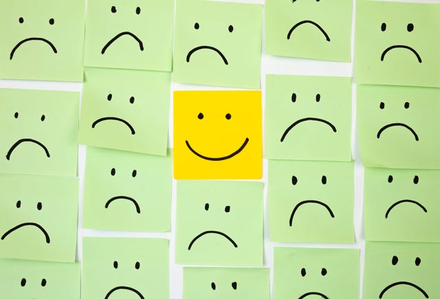 sad faces on sticky notes with one happy one