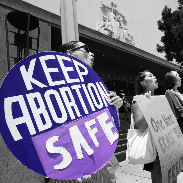 woman holding sign that reads "keep abortion safe"