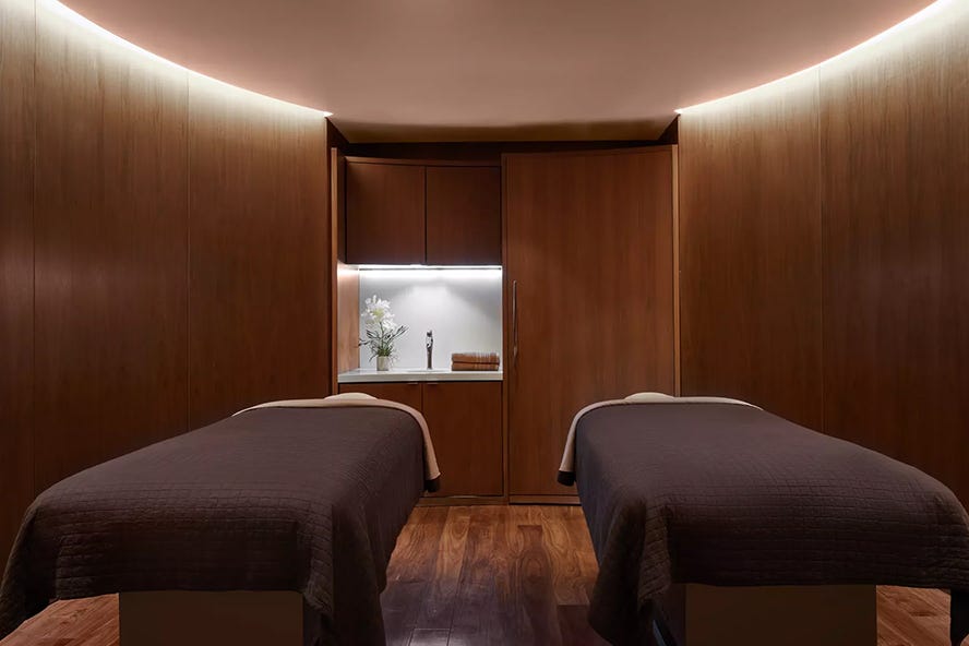 spa treatment room with two massage tables and wooden decor spa treatment room with two massage tables and wooden decor