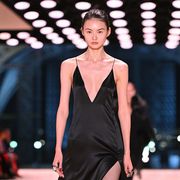 a model walks on the saint laurent runway wearing a dress with a plunge neckline to illustrate a roundup of the best sticky bras 2022