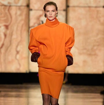 Runway fashion featuring an orange dress with dramatic sleeves Runway fashion featuring an orange dress with dramatic sleeves