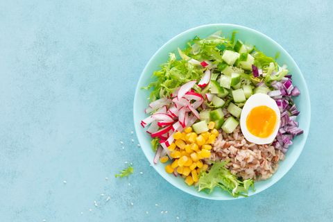 bowl of rice, egg and vegetables on blue background