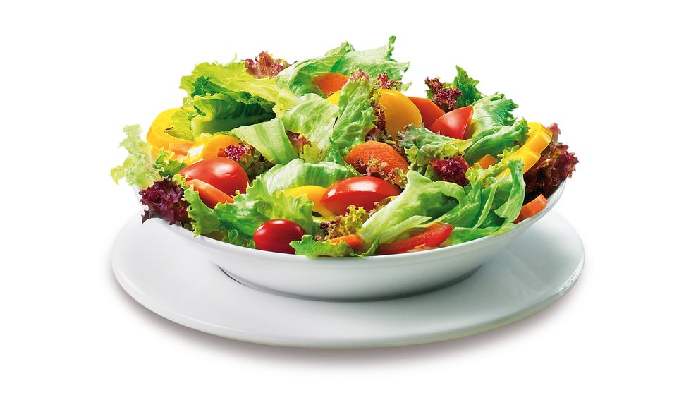 Salad In Bowl On Plate Against White Background