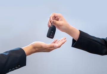 salesperson hands car keys to a customer after a successful financing agreement