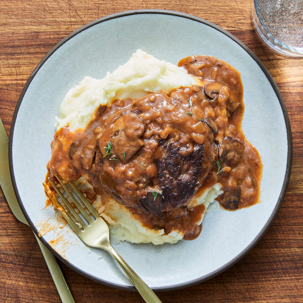 ground beef patties in a pan with mushroom gravy
