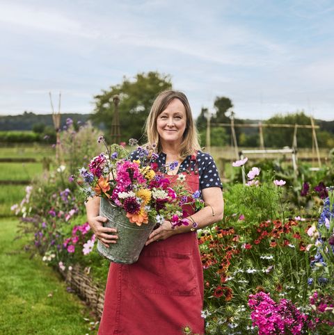 sally coulthard holding a bucket of cut flowers