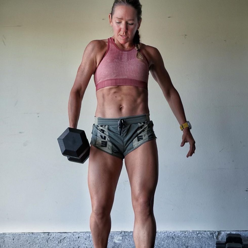 a woman does a lift with a dumbbell