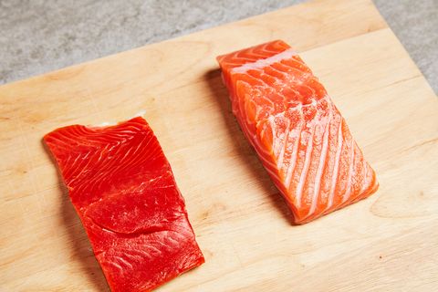 two pieces of salmon fillets on a wooden cutting board