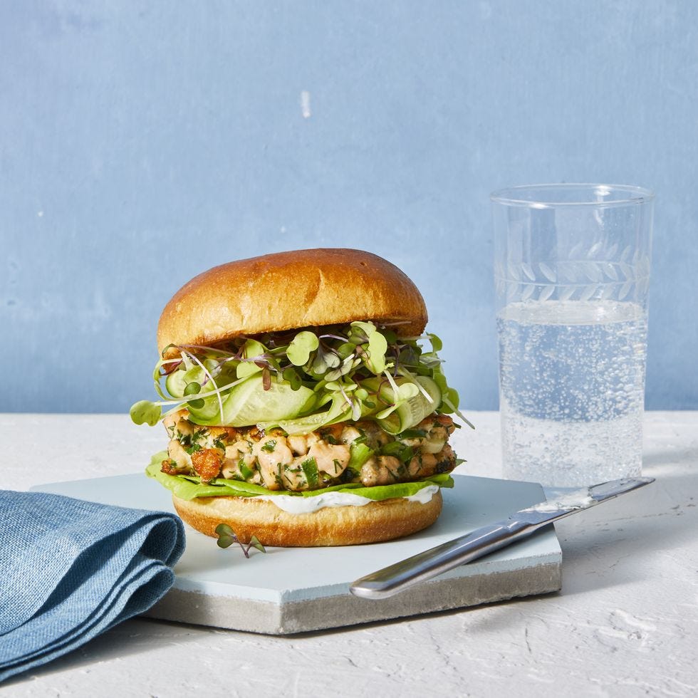 salmon spring burger with a creamy sauce against a blue background