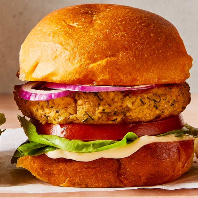 salmon burgers topped with lettuce, tomato, and sliced red onion