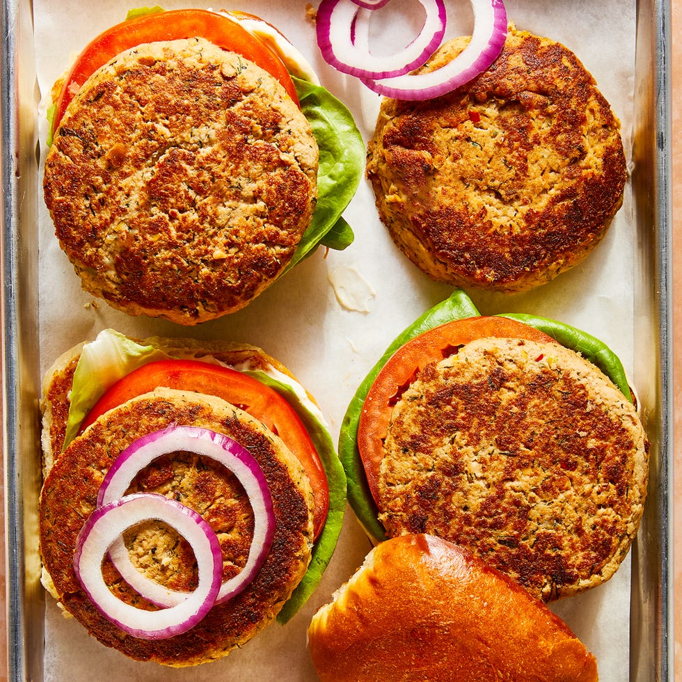 salmon burgers topped with lettuce, tomato, and sliced red onion