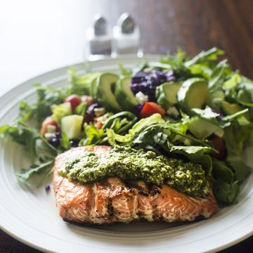 salmon fillet topped with arugula pesto and salad