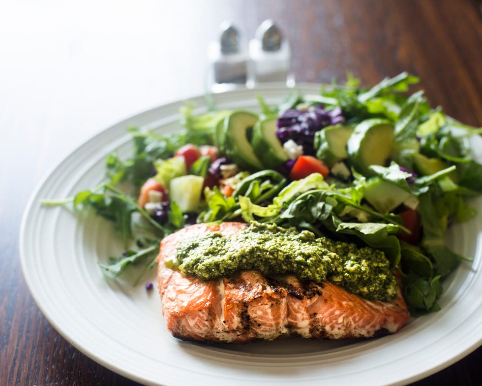 Salmon fillet topped with arugula pesto and salad