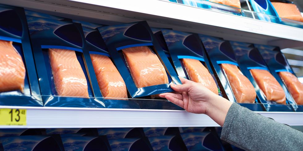 salmon fish in hand of buyer at store