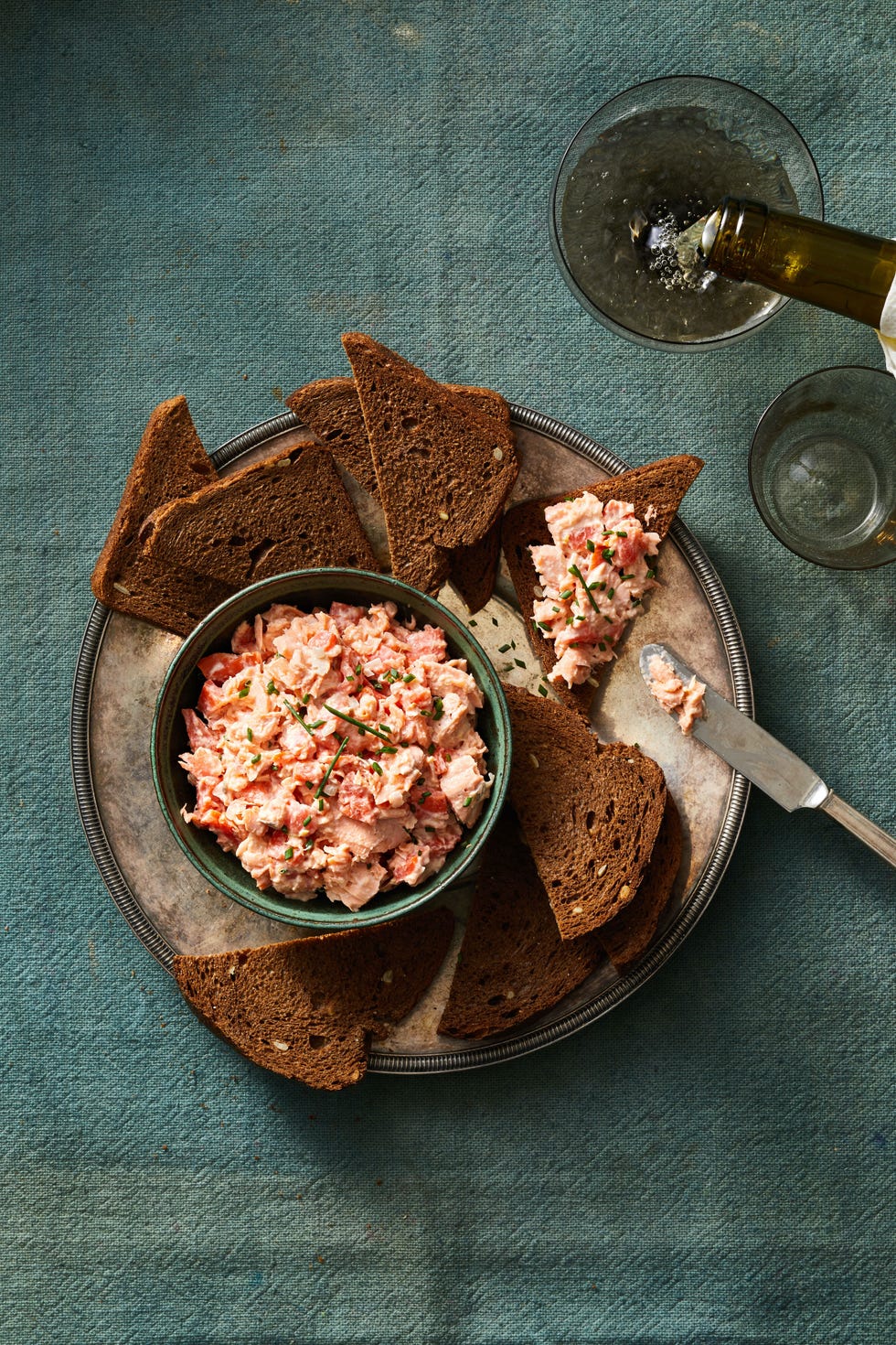 salmon rillette with slices of pumpernickel bread on the side