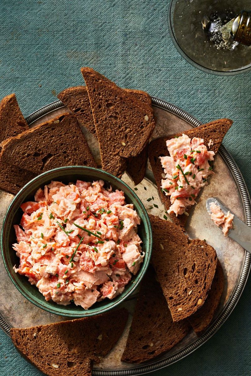 salmon rillettes spread over rye bread toast on a serving platter