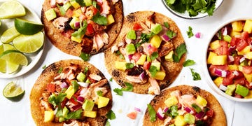 salmon tacos topped with mango salsa on a platter