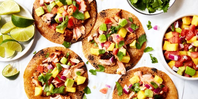 salmon tacos topped with mango salsa on a platter