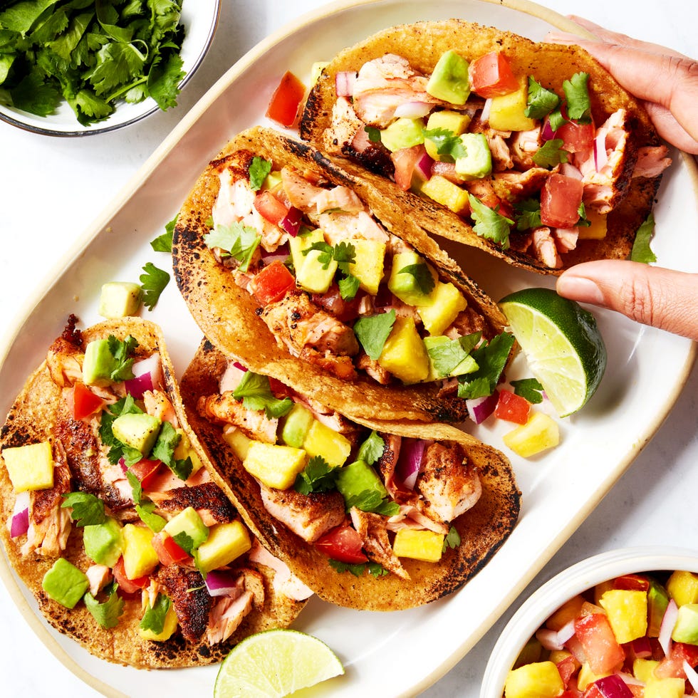 salmon tacos topped with mango salsa on a platter