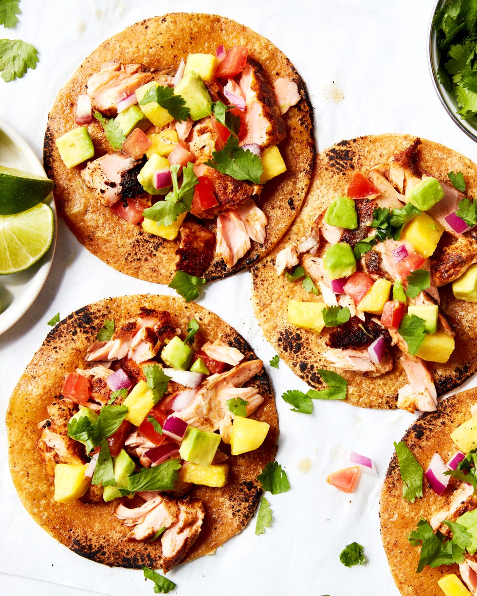 Salmon tacos topped with mango salsa served on a platter