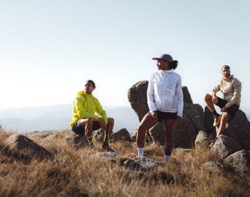 group of three individuals in athletic clothing on rocky terrain