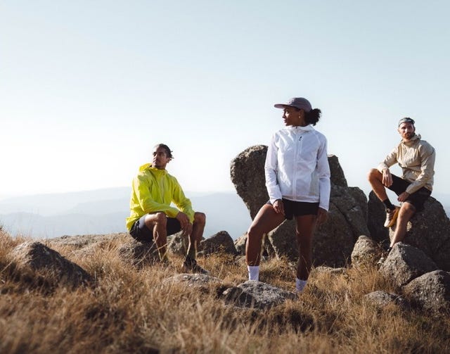 group of three individuals in athletic clothing on rocky terrain