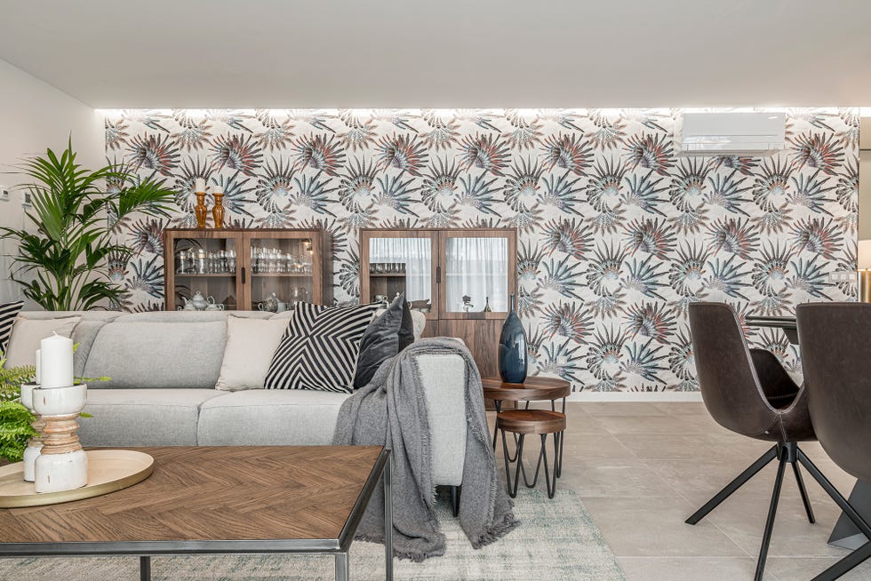 salón abierto decorado en grises con un mural floral