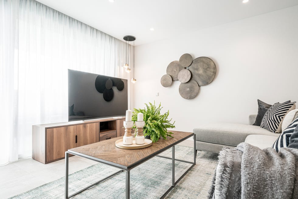 mueble tv de madera y lámpara colgante de cristal y estructura dorada