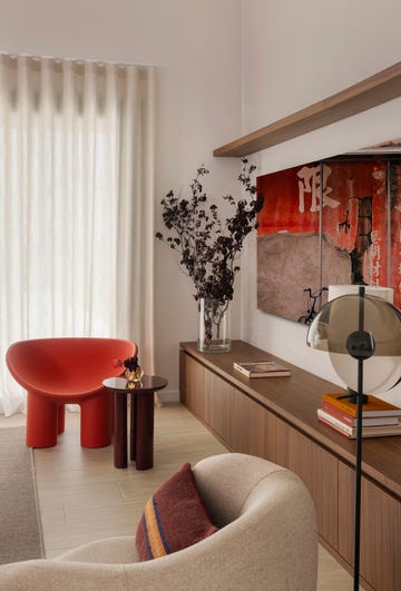silla de color naranja con mesa auxiliar y mueble de tv de madera