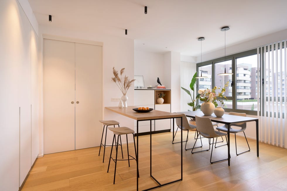 comedor con barra y taburetes y mesa con sillas