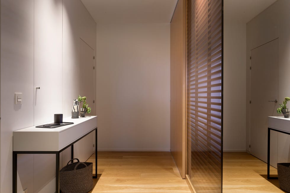 cerramiento de madera y cristal y consola blanca con patas de metal