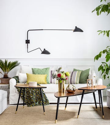 salón con sofá blanco, mesas vintage y molduras