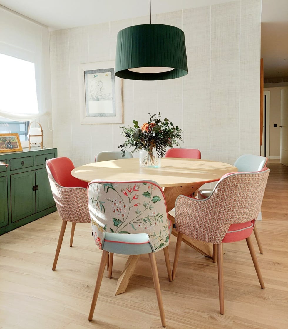 comedor con mesa redonda de madera y sillas con tapizados florales