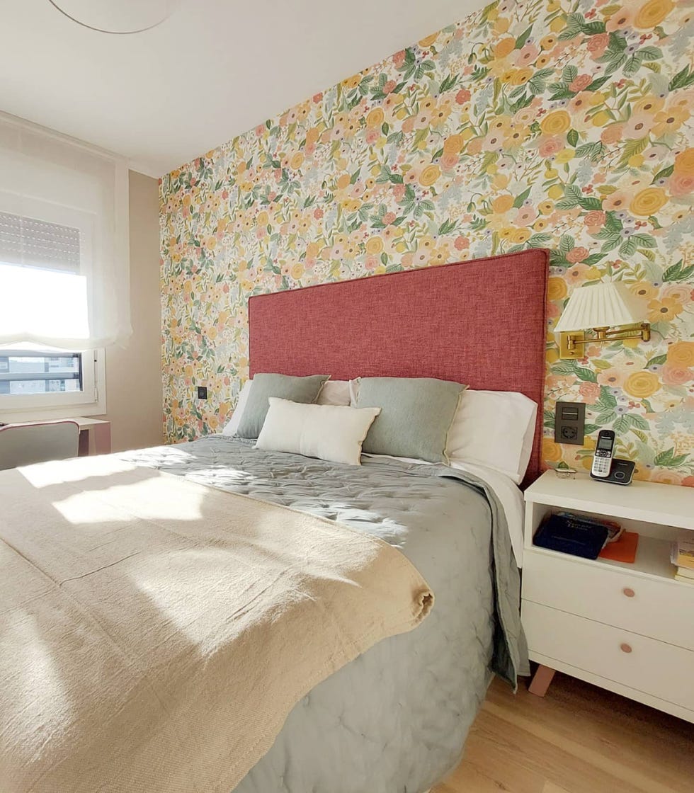 dormitorio con papel pintado floral y cabecero de color frambuesa