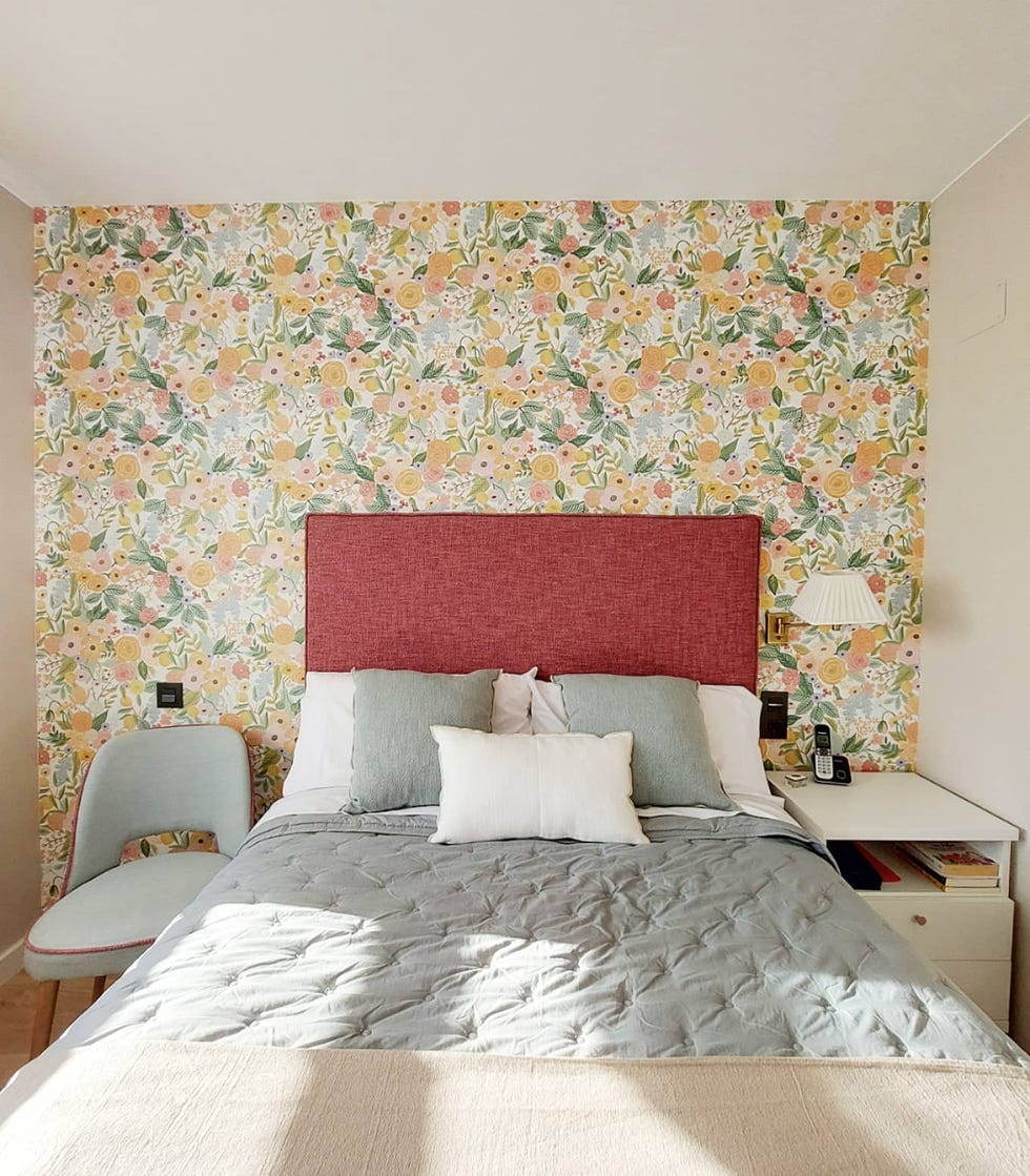dormitorio con papel pintado floral y cabecero de color frambuesa
