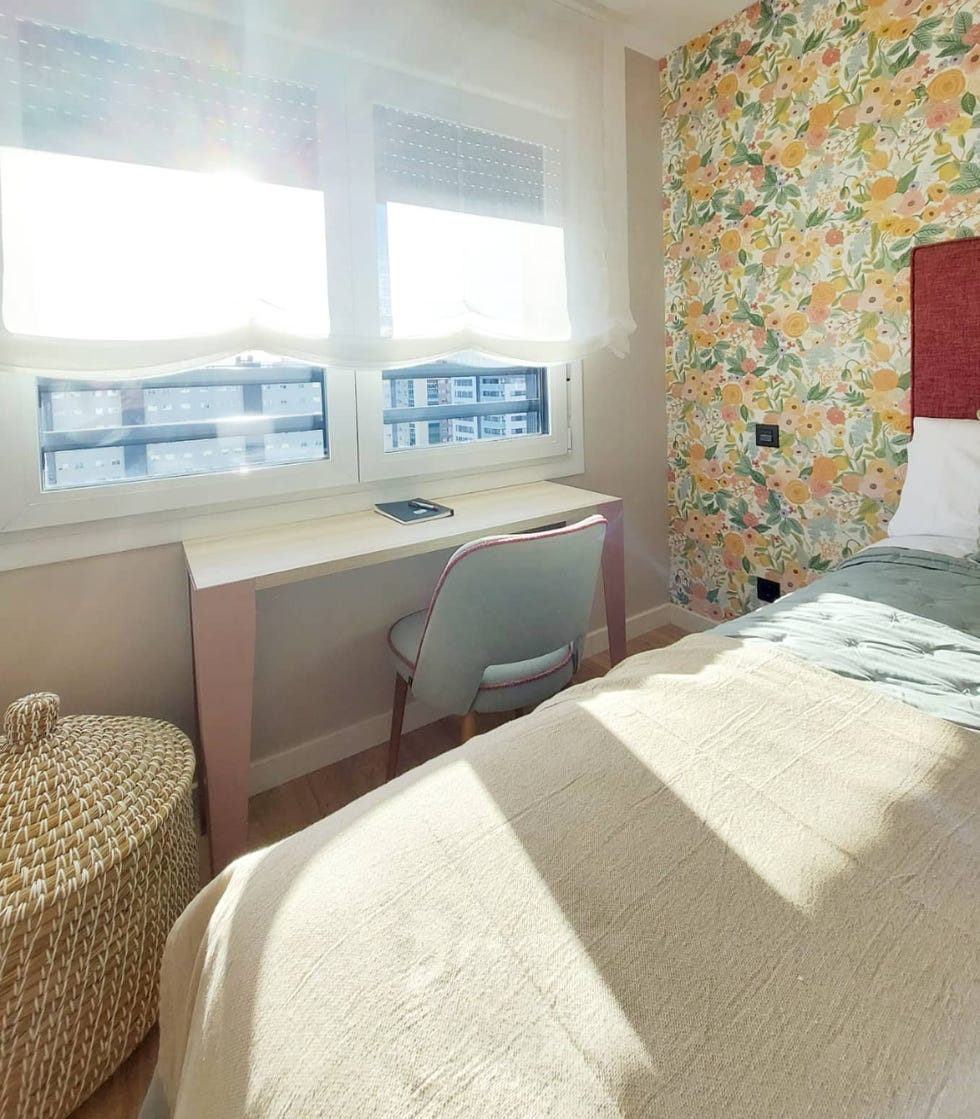 dormitorio con papel pintado floral, cabecero de color frambuesa y escritorio