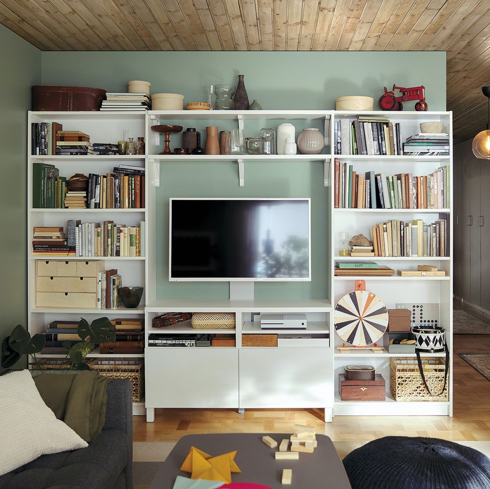 Una habitación con un estante para libros y una ventana con un