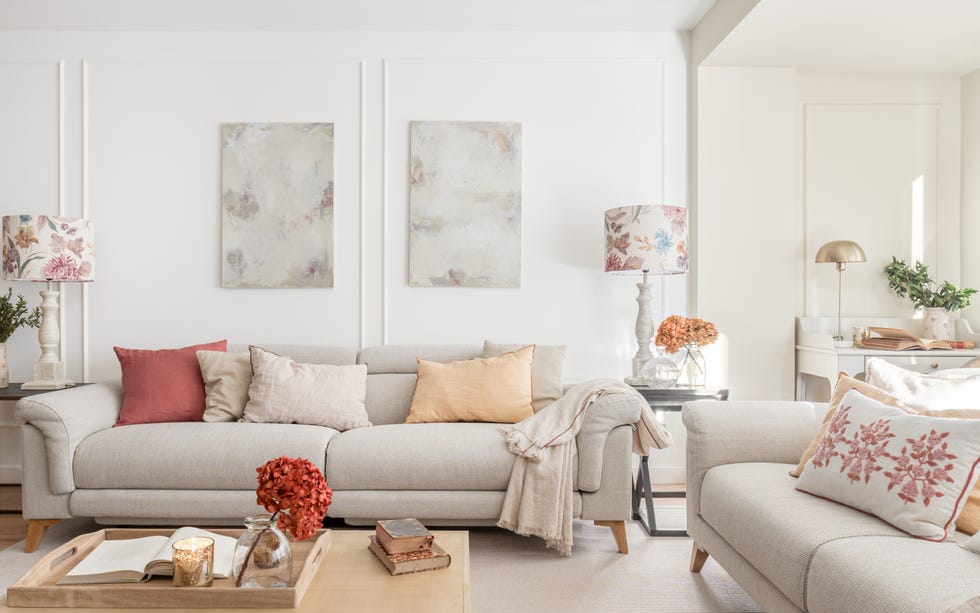 salón con dos sofás tapizados en gris y pared con molduras blancas