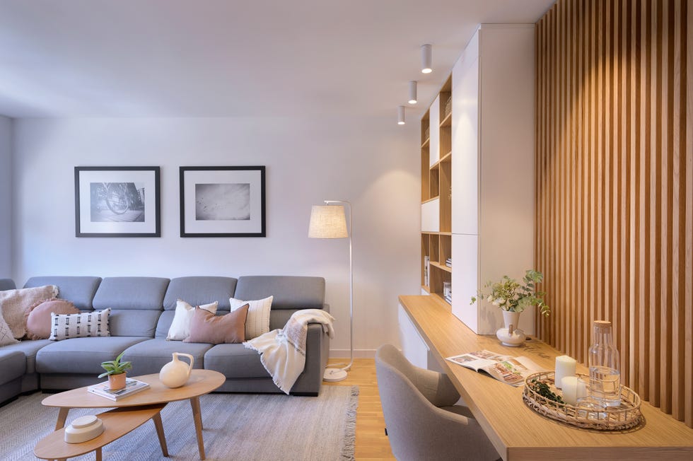 salón con sofá rinconera y escritorio de madera
